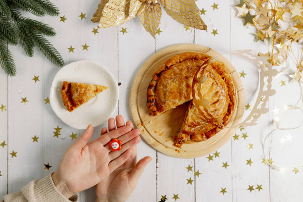 istock Woman's hands show a surprise gift from a royal galette at the table. 1930909612