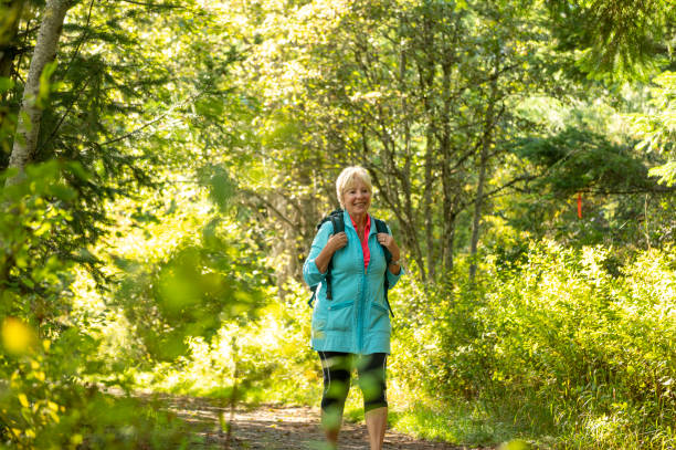 istock Senior woman hikes through forest 1930962991