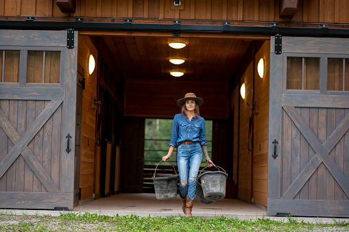 Rancher cleans out stables and mucking buckets