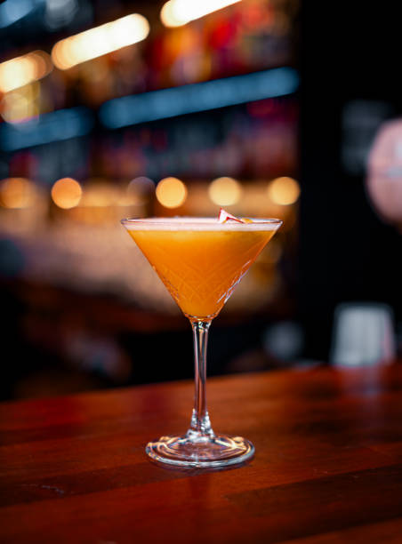 цитрусовое блаженство: апельсиновый �алкогольный коктейль с белой пеной и цедрой на столе ресторана - crushed ice colors grape fruit стоковые фото и изображения