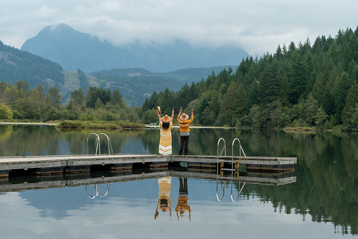 Indigenous women stand on lake pier together