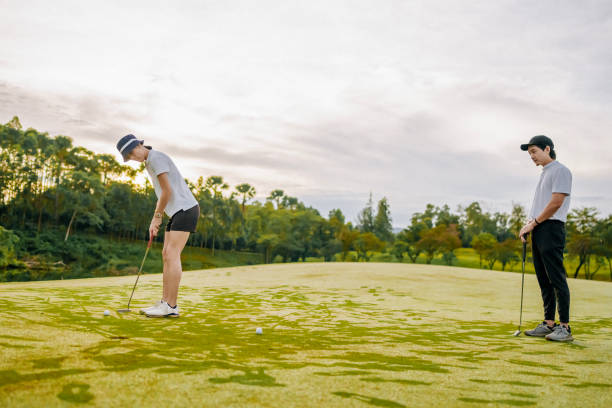 amici golfisti cinesi asiatici che giocano a golf mattina del fine settimana al campo da golf - golf swing golf golf club chipping foto e immagini stock