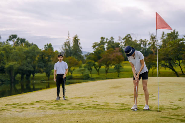 asian chinese golfers playing golf weekend morning at golf course - golf swing golf golf club chipping foto e immagini stock