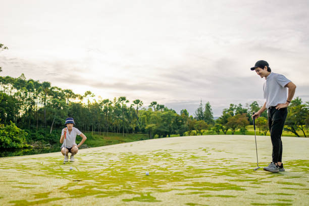 golfista cinese asiatico che misura la mattina di fine settimana di golf di gioco distante al campo da golf - golf swing golf golf club chipping foto e immagini stock