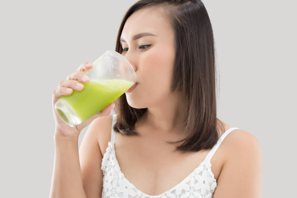 istock Asian woman drinking mixed vegetable juice. 1930982511