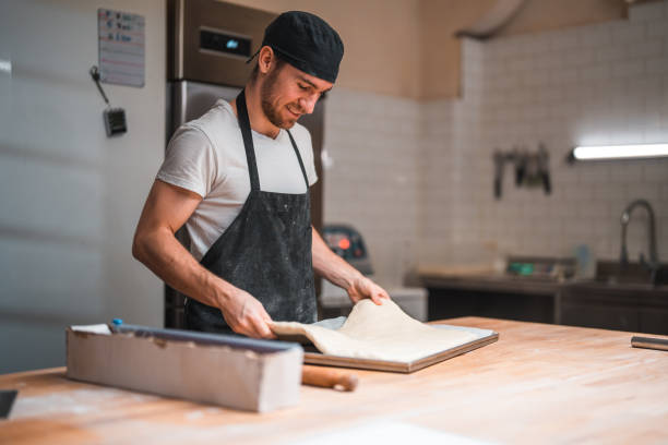 Caucasian Artisan Baker Putting Dough On A Baking Tray