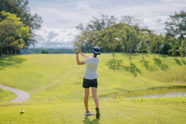 istock Asian chinese female golfer teeing off at golf course rear view 1931000116