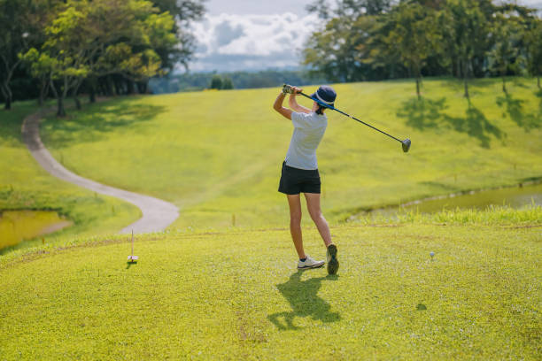 istock Asian chinese female golfer teeing off at golf course rear view 1931001478