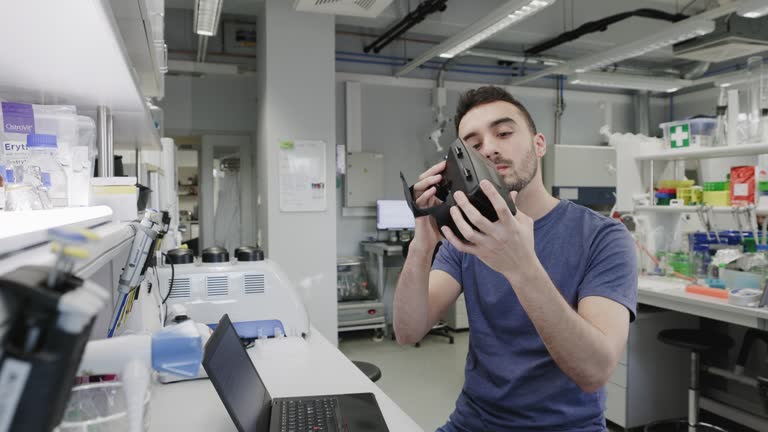 Male Latin scientist using laptop to calibrate his prototype VR glasses