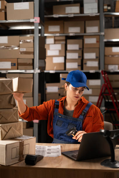 istock Sorting orders in the warehouse of an online store. Warehouse worker working with logistics management software on laptop 1931043771