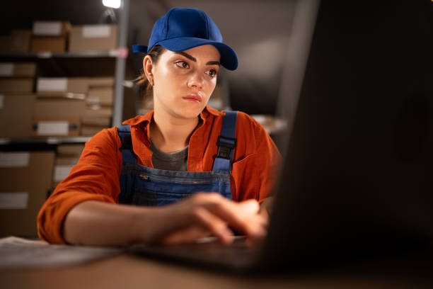istock Online store owner, warehouse worker working using laptop taking inventory of customer orders 1931043773