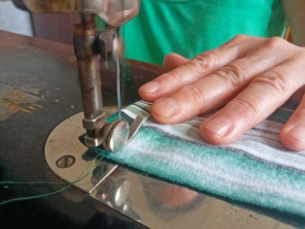 istock a seamstress sews a piece of material on a sewing machine 1931059156