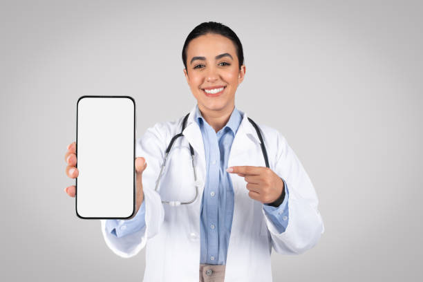 istock Doctor pointing at cellphone blank screen, space for ad and design 1931079164
