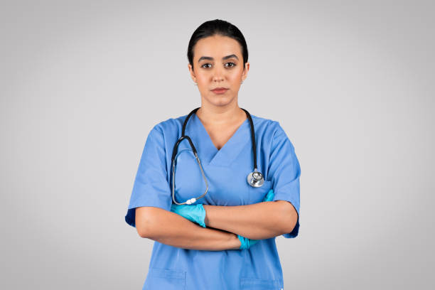 istock Confident female doctor in blue uniform posing with folded arms 1931079432
