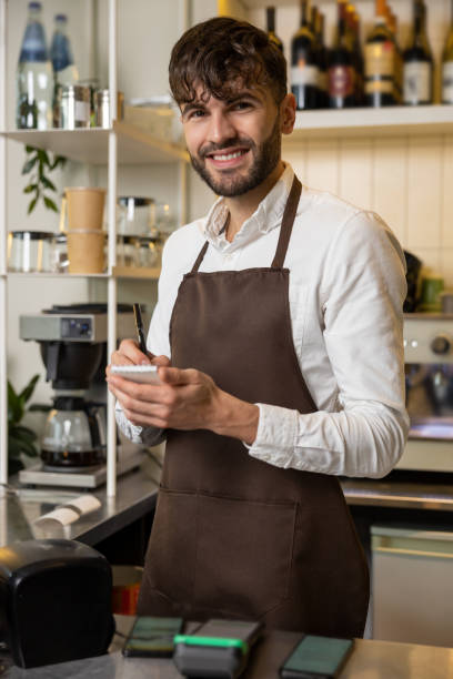 istock Waiter in pizzeria making notes and smiling 1931089163