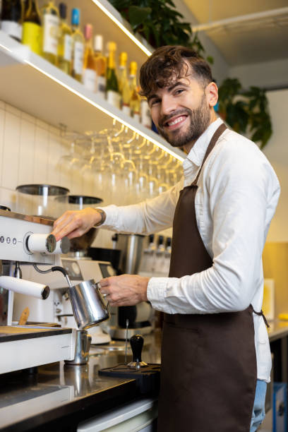 istock Smiling barista standing near coffee machine and looking contented 1931089174