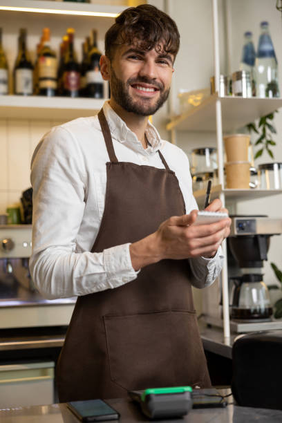 istock Waiter in pizzeria making notes and smiling 1931089177