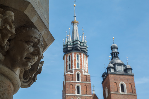 Adam Mickiewicz Monument and the towers of St Mary Basicila Krakow, Poland in the Main Market Square.