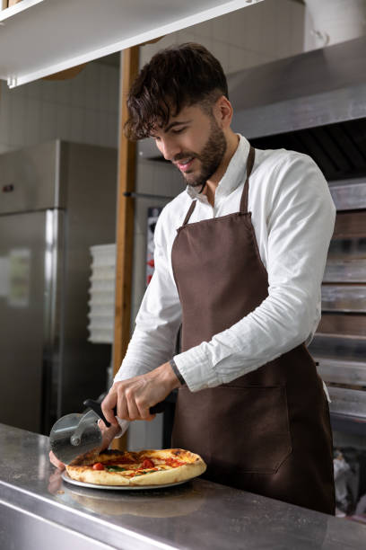 istock Dark-haired young man cooking pizza in pizzeria 1931090832