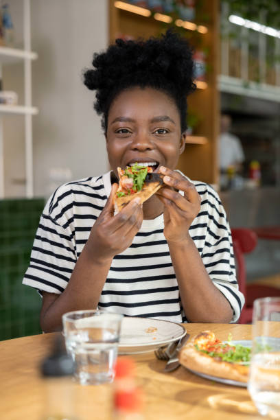 istock Cute dark-skinned young woman enjoying pizza 1931091391