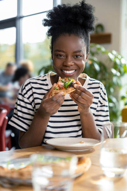 istock Cute dark-skinned young woman enjoying pizza 1931091397