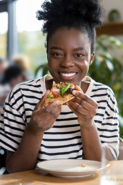 istock Cute dark-skinned young woman enjoying pizza 1931091399