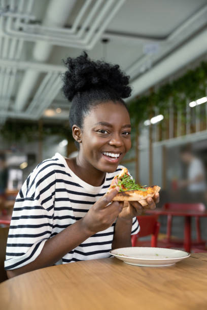 istock Pretty young dark-skinned woman eating pizza and feeling good 1931091412