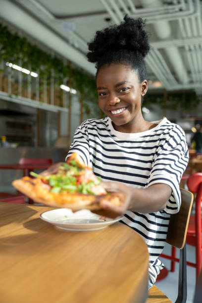 istock Pretty young dark-skinned woman eating pizza and feeling good 1931091426