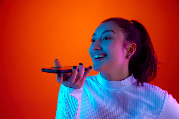 istock Excited young woman talking on phone with perfect cellular connection against gradient orange-red background in neon light. 1931099690