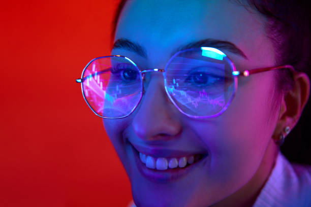 istock Smiling, happy developer, woman wears glasses working on computer looking at graphs, trading charts which reflecting in glasses. 1931099698