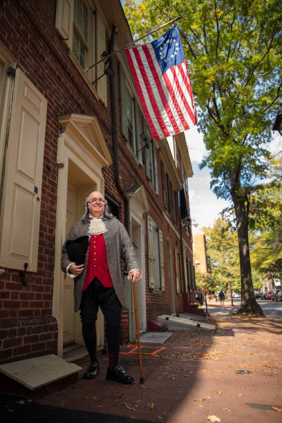벤자민 프랭클린 필라델피아 거리의 미국 국기 아래 서 있습니다. - benjamin franklin history american culture portrait 뉴스 사진 이미지