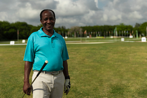 Portrait of senior golfer standing on a golf course