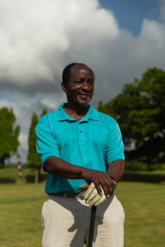 Portrait of senior golfer holding golf club