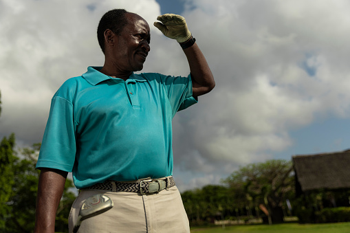 Portrait of senior golfer looking for a golf ball