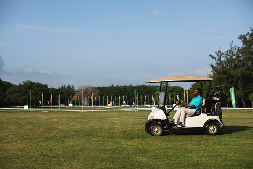 Golfcar on beautiful golf course in the evening golf course with fresh green grass field and cloud sky.