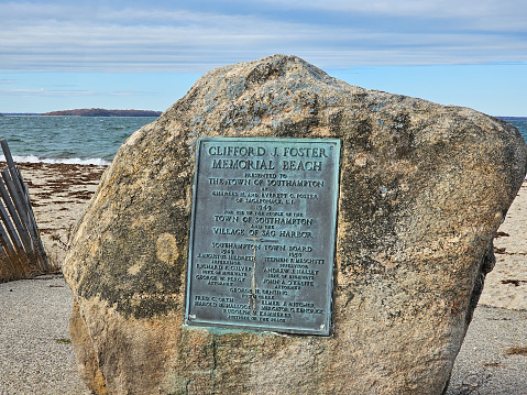 Sag Harbor, NY, USA,11.18.2023 - A plaque on a rock for Clifford J. Foster Memorial Beach in Sag Harbor, New York.
