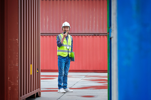 One asian male warehouse examining cargo container in commercial dock.