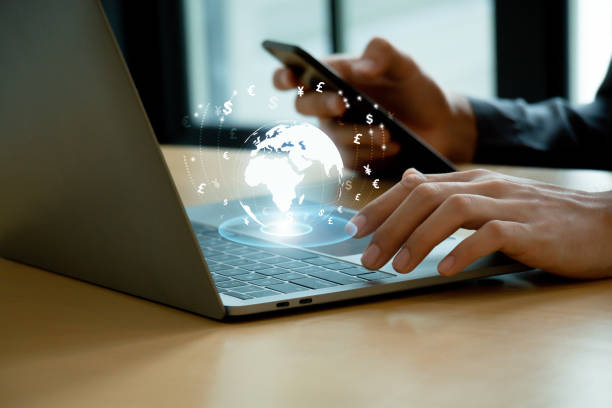 istock Businessman using laptop with crystal globe with currency. 1931373920