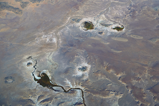 Aerial view of desert surface by Lake Eyre South, part of Kati Thanda–Lake Eyre, an endorheic salt lake basin in the east-central part of the Far North region of South Australia. The lake contains the lowest natural point in Australia, at approximately 15 m below sea level.