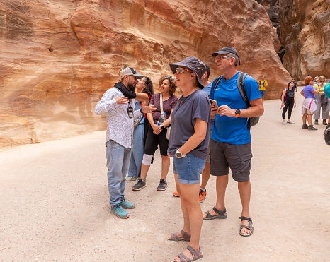 Wadi Musa, Jordan, October 05, 2023 : A local guide tells tourists about gorge Al Siq in Petra in Wadi Musa city in Jordan