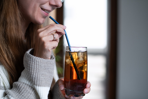 Woman using straw in her drink to avoid tooth sensitivity