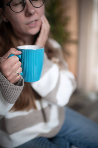 istock Woman with a cup of  hot tea suffering from tooth sensitivity 1931551804