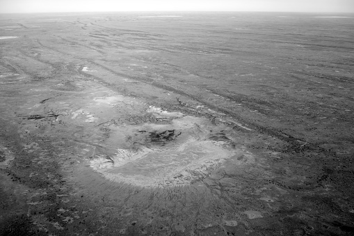 Aerial view of a isolated salt flat the vast Kati Thanda–Lake Eyre, an endorheic salt lake basin in the east-central part of the Far North region of South Australia. The lake contains the lowest natural point in Australia, at approximately 15 m below sea level.