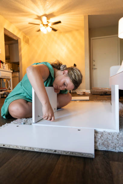 istock Woman assembles a coffee table in her apartment 1931585186