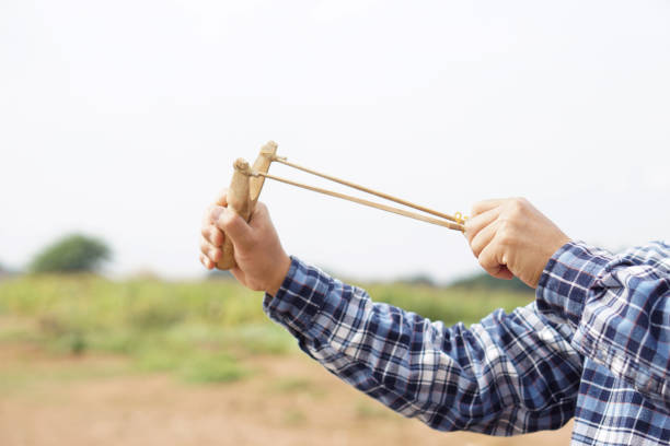 istock Hands hold wooden slingshot for playing shooting game 1931653084