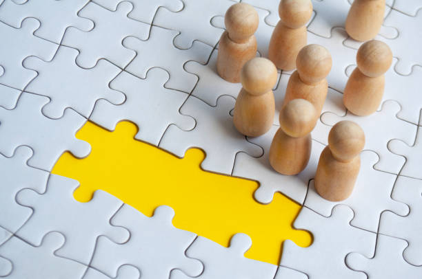 istock Missing jigsaw puzzle with wooden dolls. Representing hiring and copy space. 1931664550