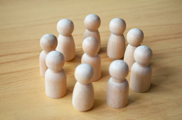 istock A wooden doll surrounded by other dolls. Representing either leadership or harassment 1931666610