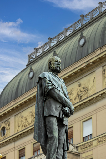 Zagreb, Croatia - September 23, 2023: Statue of Petar Preradovic in front of Art Nouveau style Palace of first Croatian savings bank located on the Petar Preradovic Square