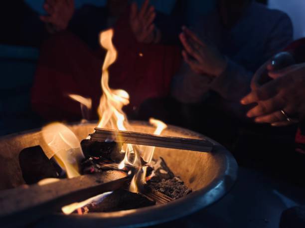 istock People warming hands while sitting around a bonfire in winter at home. 1931731540