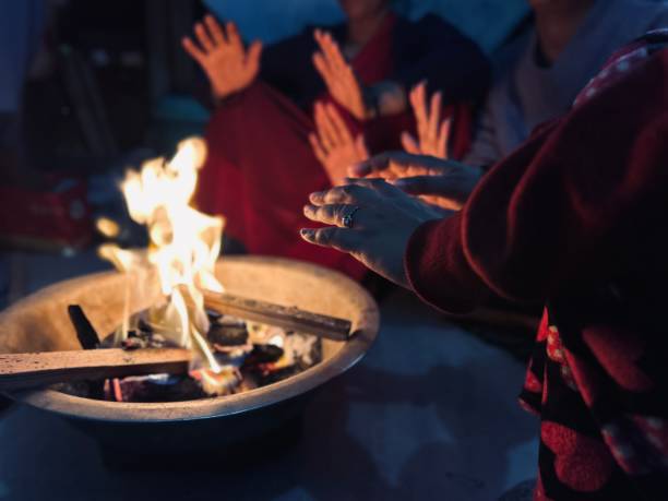 istock People warming hands while sitting around a bonfire in winter at home. 1931732571